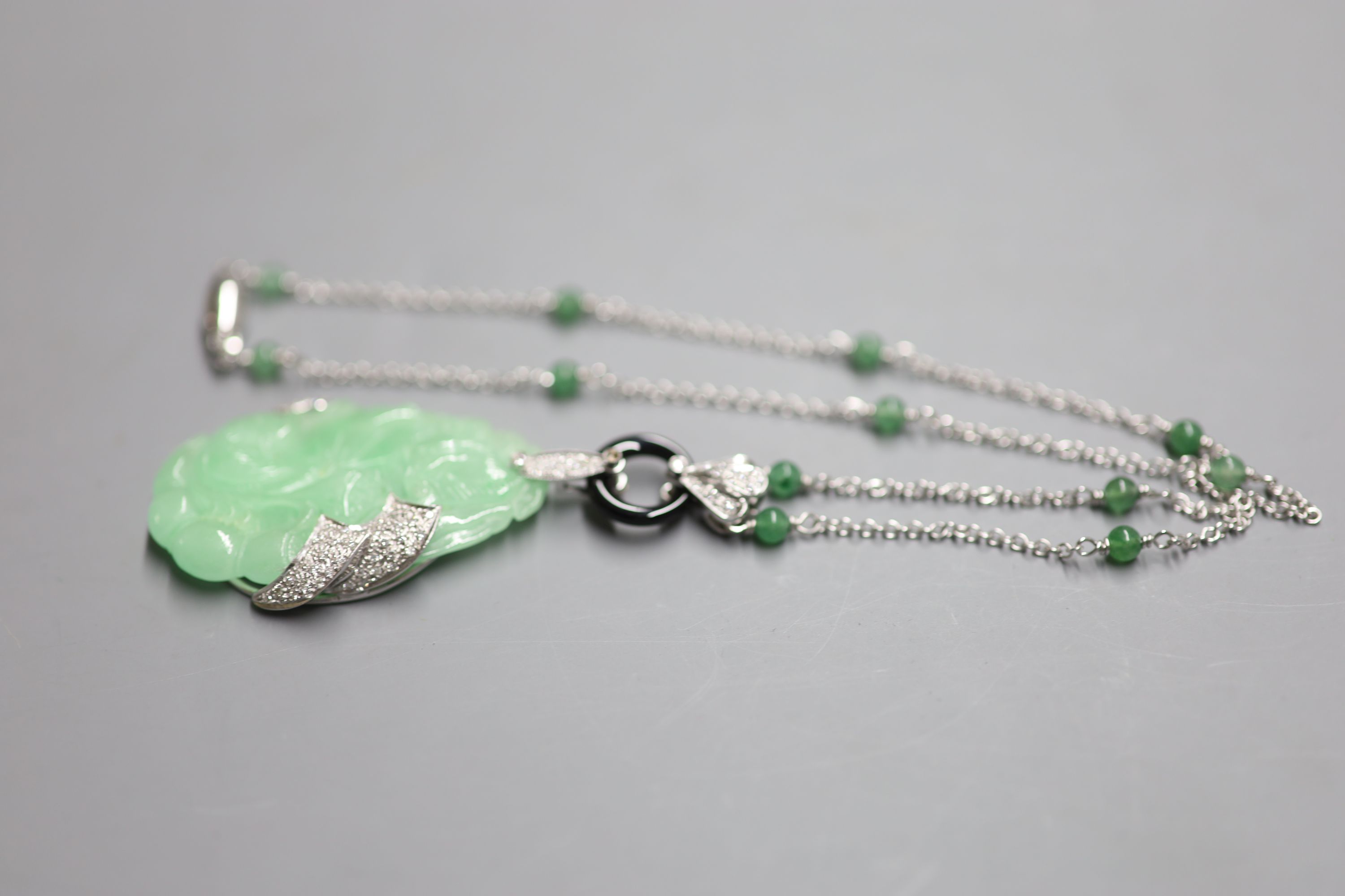 A modern Italian 750 white metal, jadeite, black onyx and diamond set pendant necklace,